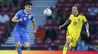 Ruslan Malinovskyi (kiri) and Kristoffer Olsson (kanan) berebut bola ketika pertandingan babak 16 Euro 2020 antara Swedia melawan Ukraina yang berlangsung di Hampden Park, Glasgow, Skotlandia pada Selasa (29/06/2021). (AP/Pool/Robert Perry)