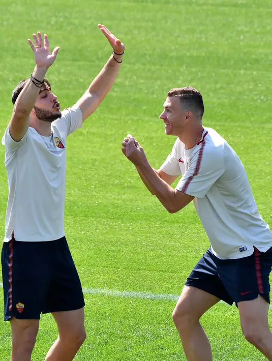 Pemain AS Roma, Kostas Manolas (kiri) dan Edin Dzeko bercanda saat berlatih di Trigoria, Roma, Italia, Senin (23/4). Leg pertama semifinal Liga Champions antara Liverpool dan AS Roma akan berlangsung di Anfield. (Alberto PIZZOLI/AFP)