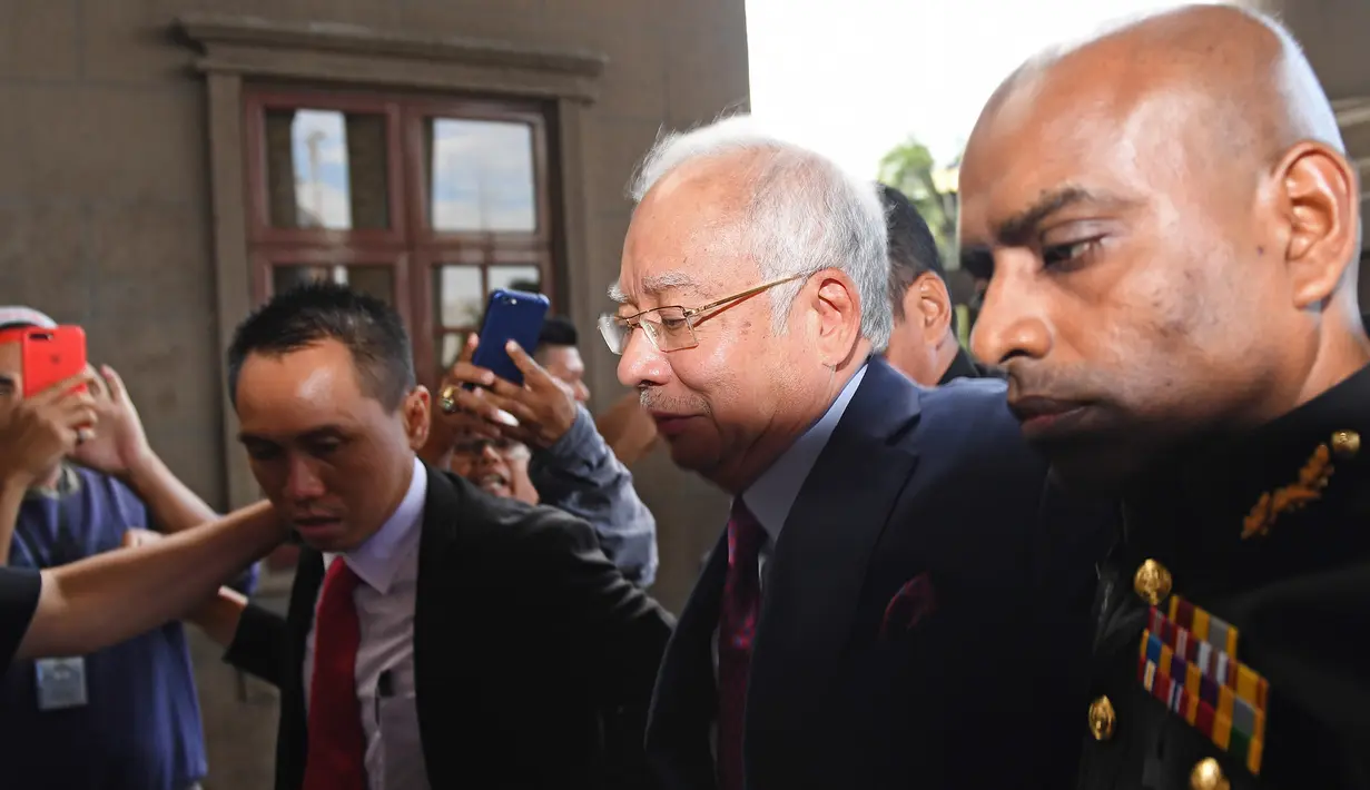 Mantan Perdana Menteri Malaysia, Najib Razak tiba untuk menjalani sidang dakwaan di Pengadilan Kuala Lumpur, Rabu (4/7). Sejumlah pejabat partai Najib, United Malaysia National Organisation (UMNO), turut hadir dalam persidangan. (AFP/MOHD RASFAN)