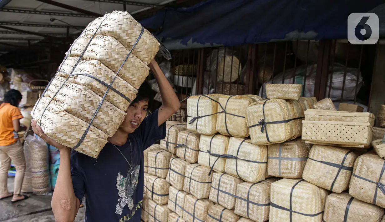 Pedagang membawa besek bambu di Pasar Jatinegara, Jakarta, Kamis (1/7/2021). Menurut pedagang, penjualan besek untuk daging kurban jelang Idul Adha 2021 diharapkan mengalami peningkatan, mengingat kebijakan Pemprov DKI melarang penggunaan kantong plastik sekali pakai. (Liputan6.com/Faizal Fanani)