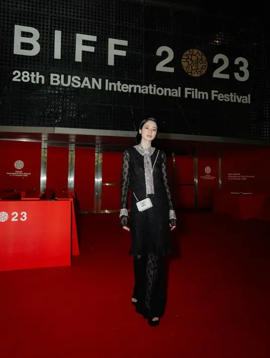 Outfit renda berlayar itu berwarna hitam terlihat elegan dengan syal silver dan sling bag putih [@laurabas]