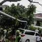 Sebuah mobil tertimpah lampu jalanan di kawasan jalan purworejo Menteng, Jakarta, Senin (27/11). Akibat hujan deras dan angin kencang sebuah pohon tumbang dan lampu jalan mengenai mobil Alphard putih yang terparkir. (Liputan6.com/Faizal Fanani)