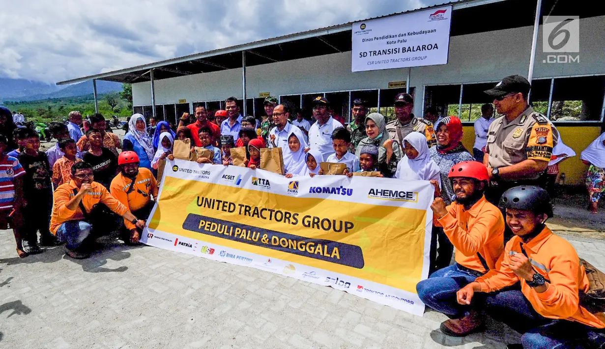 Sejumlah siswa sekolah, perwakilan United Tractors dan jajaran pemda setempat foto bersama di depan Sekolah Dasar Transisi Balaroa pasca gempa dan tsunami Palu dan Donggala di Petobo dan Balaroa, Sulawesi Tengah, (16/11). (Liputan6.com/HO/Eko)