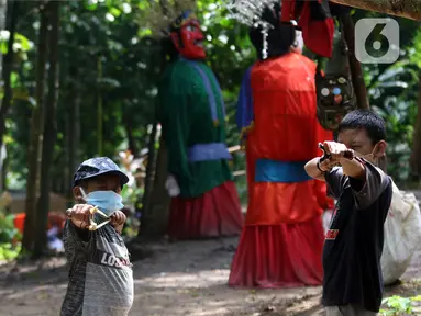 Anak-anak yang tergabung dalam Ketapel Anak Ciliwung (Kancil) bermain ketapel di kawasan Ciliwung Muara Baru, Jakarta, Selasa (9/11/2021). Selain melestarikan permainan tradisional, bermain ketapel dapat melatih kesabaran, konsentrasi dan motorik otak kanan bagi anak. (Liputan6.com/Herman Zakharia)