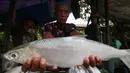 Pedagang memperlihatkan ikan bandeng di kawasan Rawabelong, Jakarta, Jumat (5/2/2016). Menjelang perayaan Imlek, para pedagang ikan bandeng mulai marak di Rawabelong. (Liputan6.com/Angga Yuniar)