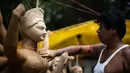 Seorang perajin membuat patung dewi Durga menjelang festival 'Durga Puja' di sebuah workshop di New Delhi, India, Rabu (14/10/2020). Durga Puja merupakan festival tahunan di Asia Selatan untuk memuja dewi Durga dari agama Hindu. (Photo by Jewel SAMAD / AFP)