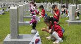 Murid-murid taman kanak-kanak berdoa di depan nisan tentara yang gugur selama Perang Korea 1950-1953 pada malam Memorial Day Korea Selatan di Pemakaman Nasional, Seoul, Korea Selatan, Senin (5/6/2023). Memorial Day di Korea Selatan diperingati setiap tanggal 6 Juni tiap tahunnya. (AP Photo/Ahn Young-joon)