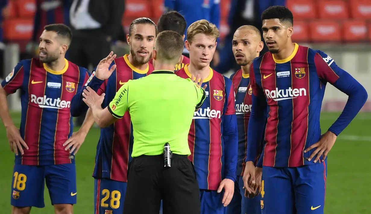 Para pemain Barcelona mempertanyakan keputusan wasit Alejandro Hernandez Fernandez usai berakhirnya laga lanjutan Liga Spanyol 2020/21 melawan Valencia di Camp Nou Stadium, Barcelona, Sabtu (19/12/2020). Barcelona bermain imbang 2-2 dengan Valencia. (AFP/Lluis Gene)