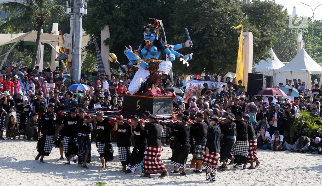 Peserta mengarak ogoh-ogoh dalam Festival Ogoh-Ogoh di Pantai Lagoon Ancol, Jakarta, Minggu (18/3). Terdapat 6 ogoh-ogoh yang dihadirkan dalam festival ini. (Liputan6.com/Arya Manggala)