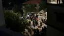Tim penyelamat Pertahanan Sipil Yordania melakukan operasi pencarian terhadap penghuni sebuah bangunan perumahan berlantai empat yang runtuh di Amman, Yordania, Selasa (13/9/2022). Perdana Menteri Yordania Bisher Al Khasawneh sudah tiba di lokasi kejadian dan memerintahkan penyelidikan guna memastikan penyebabnya. (AP Photo/Raad Adayleh)