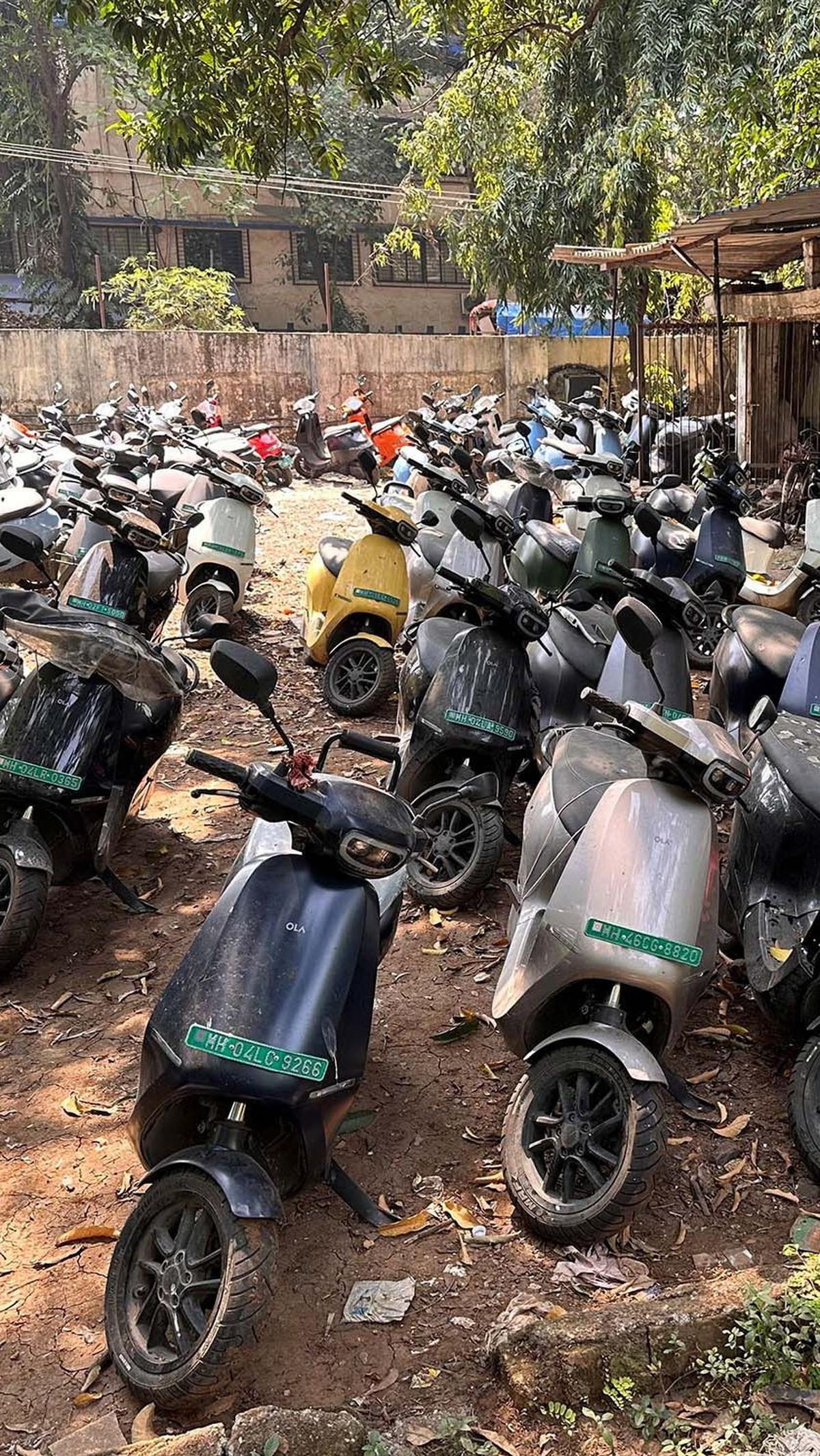 Sejumlah motor listrik Ola Electric terparkir di lapangan berlumpur dekat bengkel resmi di Thane, Mumbai, pada 25 Oktober 2023.