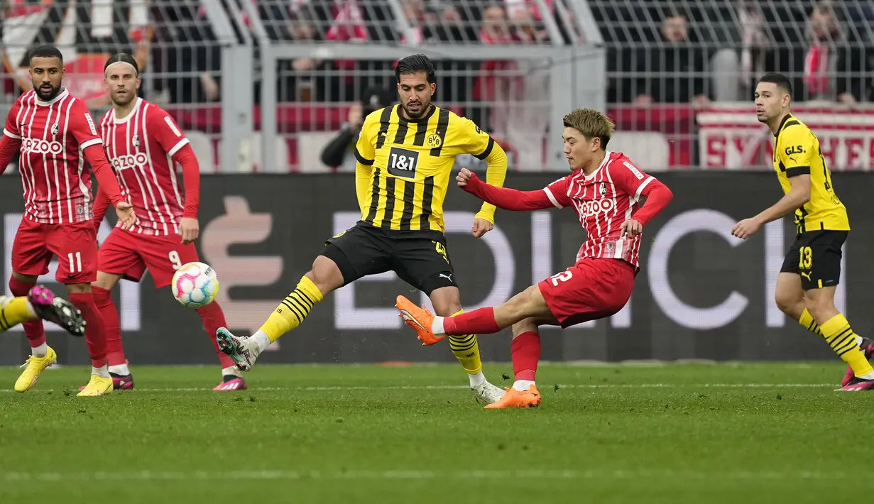 Pemain SC Freiburg, Ritsu Doan melepaskan tendangan di depan pemain Borussia Dortmund, Nico Schlotterbeck dalam laga Bundesliga 2022/2023 di Dortmund (4/2/2023). Pemain yang sejak awal musim 2022/2023 memperkuat SC Freiburg ini kini memiliki nilai pasar senilai 15 juta euro atau setara Rp244 miliar. (AP Photo/Martin Meissner)