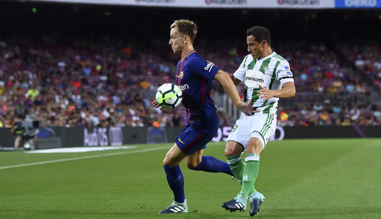 Pemain Ivan Rakitic, berusaha melewati adangan pemain Real Betis pada lanjutan La Liga Spanyol di Camp Nou stadium, Barcelona, (20/8/2017). Barcelona menang 2-0.  (AFP/Josep Lago)