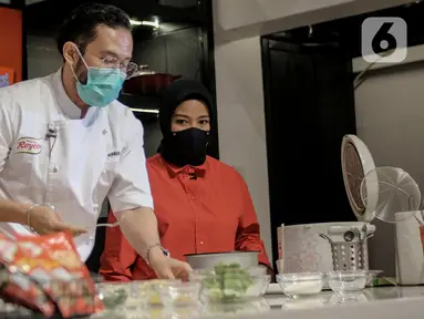 Chef Norman bersama Vokalis band KotaK, Tantri saat membuat hidangan bernutrisi menggunakan bahan-bahan dari daftar "50 Pangan untuk Masa Depan” pada peluncuran Royco Kaldu Ayam dan Sapi di Jakarta, Selasa (26/01/2021). (Liputan6.com/Pool)