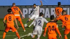 Pemain Real Madrid Karim Benzema mencetak gol ke gawang Valencia pada pertandingan Liga Spanyol di Stadion Alfredo Di Stefano, Madrid, Spanyol, Minggu (14/2/2021). Real Madrid menggeser Barcelona di peringkat dua klasemen usai menaklukkan Valencia 2-0. (AP Photo/Manu Fernandez)