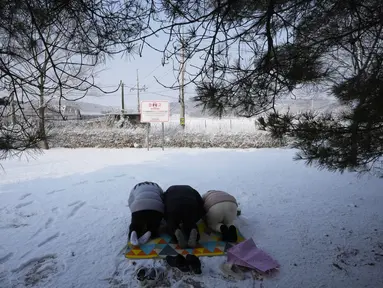 Pengungsi Korea Utara dan anggota keluarganya memberikan penghormatan kepada leluhur mereka untuk merayakan tahun Baru Imlek saat mengunjungi Paviliun Imjingak dekat perbatasan dengan Korea Utara, di Paju, Korea Selatan, Selasa (1/2/2022). (AP Photo/Ahn Young-joon)