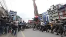 Warga Nepal menarik kereta Dewa Rato Machhindranath dalam sebuah festival keagamaan di Lalitpur, Nepal (3/9/2020). Petugas polisi dengan perlengkapan anti huru hara memblokir para pengunjuk rasa ketika mereka memindahkan kereta, menyiram mereka dengan meriam air. (AP Photo/Niranjan Shrestha)