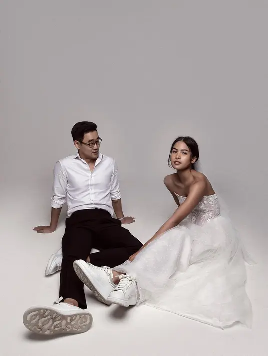 Gaya menarik Maudy Ayunda pakai off-the-shoulder white dress untuk momen preweddingnya. Padu padan yang membuat penampilan Maudy di sini lebih menarik adalah veil dan sneakers putih serasi yang sempurna. [Foto: Instagram/maudyayunda]