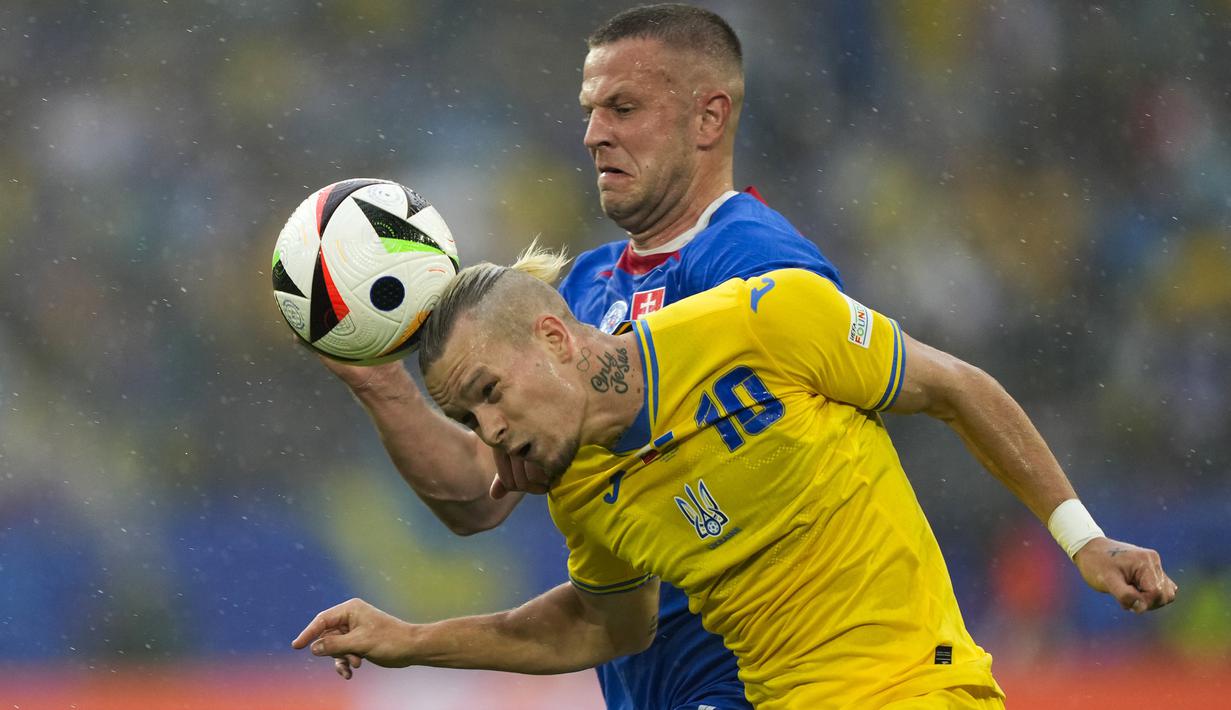 Striker Timnas Ukraina, Mykhailo Mudryk (depan) berebut bola dengan bek Timnas Slovakia, Denis Vavro pada laga matchday kedua Grup E Euro 2024 di Merkur Spiel-Arena, Dusseldorf, Jerman, Jumat (21/6/2024). (AP Photo/Martin Meissner)