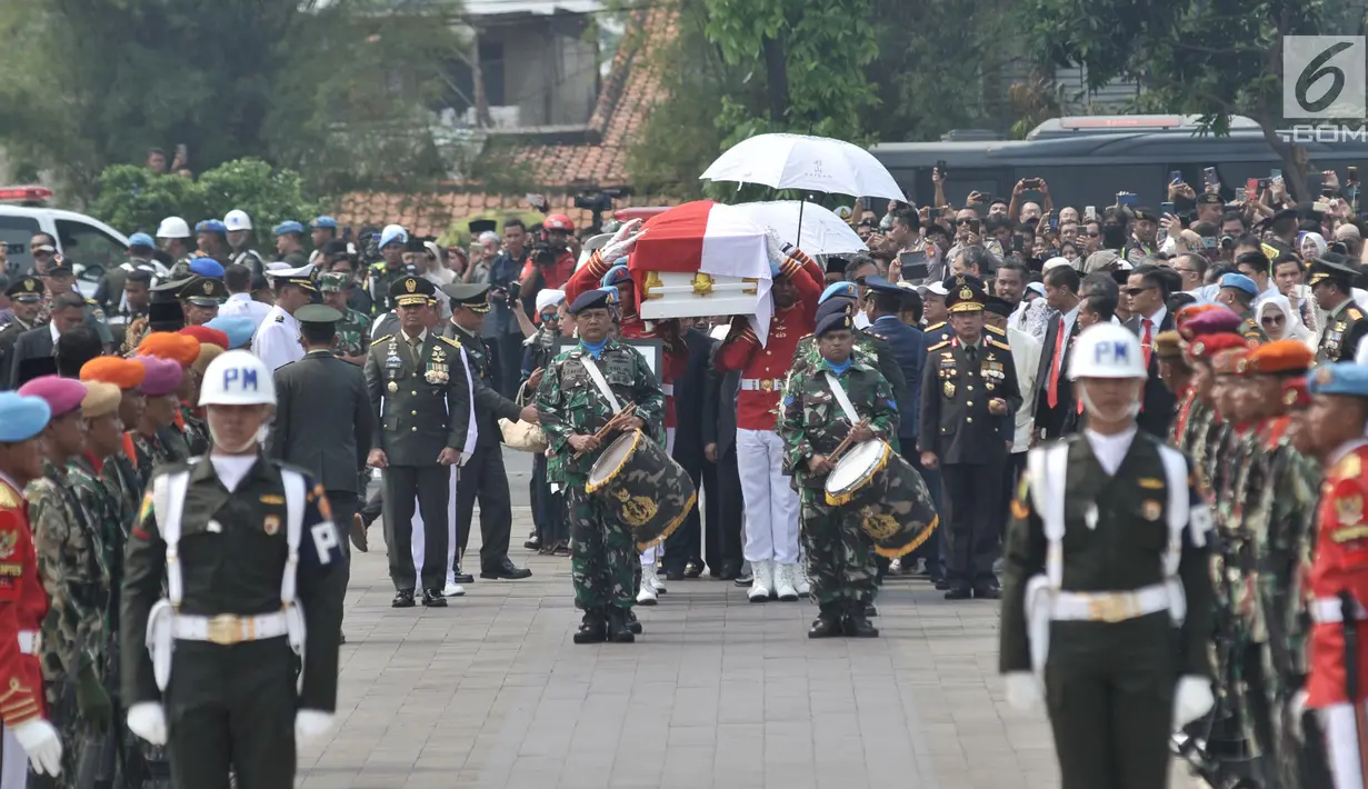 Anggota Paspampres mengusung peti jenazah almarhum Presiden ke-3 RI BJ Habibie menuju liang lahat saat tiba di Taman Makam Pahlawan (TMP) Kalibata, Jakarta, Kamis (12/9/2019). BJ Habibie meninggal pada Rabu (11/9/2019) pukul 18.05 WIB setelah menjalani perawatan di RSPAD. (merdeka.com/Iqbal Nugroho)