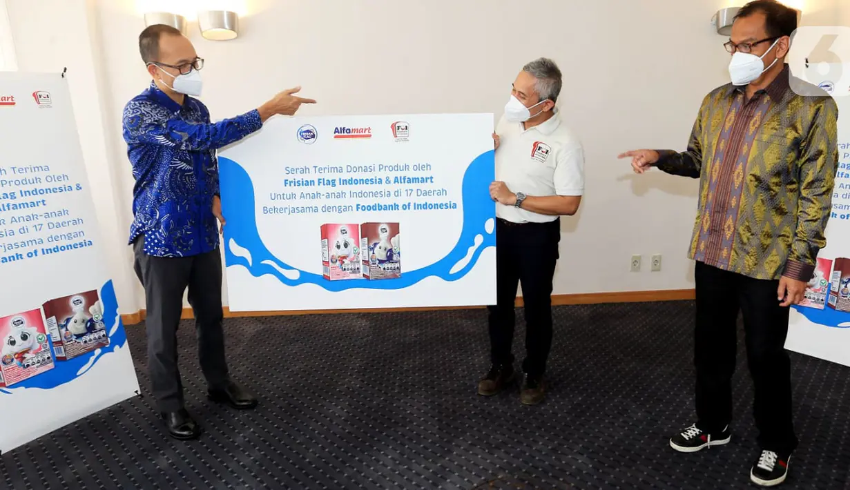 Corporate Affairs Director FFI Andrew F. Saputro (kiri) bersama Corcomm GM Alfamart Nur Rachman (kanan) secara simbolis menyerahkan produk donasi berupa 100 ribu kotak susu cair anak FRISIAN FLAG Milky kepada CEO FOI Hendro Utomo (tengah) di Jakarta, Jumat (15/10/2021). (Liputan6.com/HO/FFI)