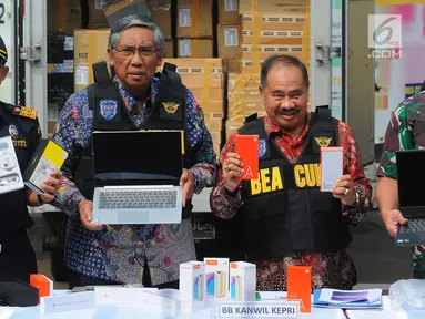Wakil Menteri Keuangan Mardiasmo (tengah) bersama Kepala PPATK Kiagus Ahmad Badaruddin (kanan) dan Dirjen Bea dan Cukai Heru Pambudi (kiri) menunjukkan barang bukti produk elektronik ilegal saat konferensi pers di Kantor Pusat Bea Cukai, Jakarta, Selasa (30/4/2019). (Liputan6.com/Angga Yuniar)