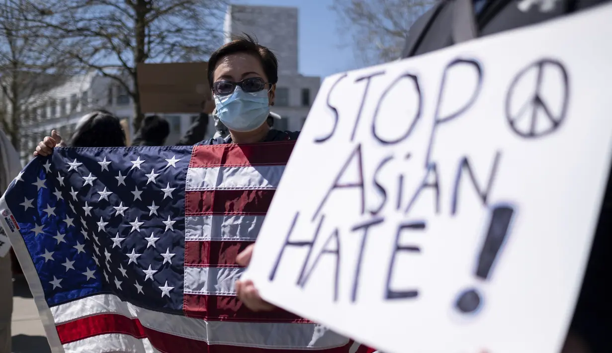 Lucy Lee memegang bendera Amerika saat unjuk rasa "Stop Asian Hate" di luar Gedung Kongres Georgia di Atlanta, Sabtu (20/3/2021). Ratusan demonstran berkumpul mendukung komunitas Asia-Amerika setelah penembakan di tiga tempat spa yang menewaskan 8 orang, termasuk 6 wanita Asia. (AP Photo/Ben Gray)