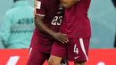 Gelandang Qatar, Mohammed Waad memeluk rekan setimnya Assim Madibo setelah kalah 1-3 dari Senegal dalam pertandingan grup A Piala Dunia di Stadion Al Thumama di Doha, Qatar, Jumat, 25 November 2022. Hasil ini membuat Qatar bernasib sama seperti Afrika Selatan pada 2010, yang juga terhenti di fase grup. (AP Photo/Petr Josek)