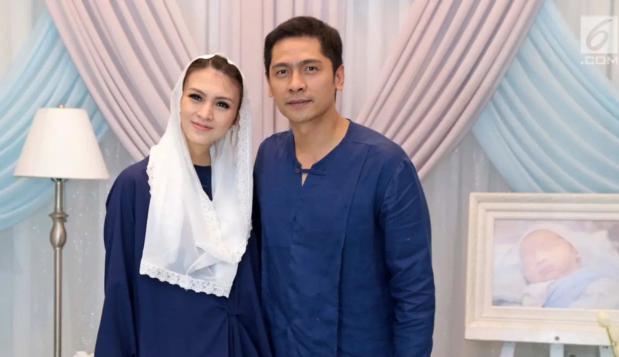 Pasangan selebritis Adi Nugroho dan Donita berpose usai prosesi aqiqah anak kedua mereka, Parvaiz Farezell Shaquill Nugroho di Kebayoran View, Tangerang Selatan, Kamis (18/1). (Liputan6.com/Herman Zakharia)