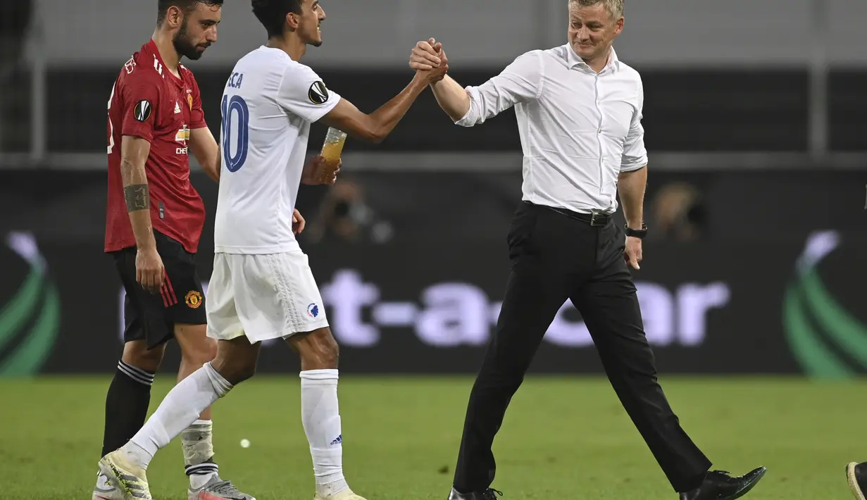 Pelatih Manchester United, Ole Gunnar Solskjaer bersalaman dengan pemain Copenhagen, Zeca usai pertandingan perempat final Liga Europa di RheinEnergieStadion, di Cologne, Jerman (10/8/2020). MU lolos ke babak semifinal Liga Europa usai menang 1-0. (Sascha Steinbach/Pool via AP)