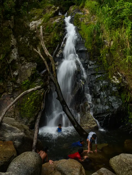 Anak-anak bermain sambil menikmati air terjun di Samadua, Provinsi Aceh pada 9 Juli 2020. Aceh punya banyak destinasi wisata alam  mempesona yang patut dikunjungi. (Photo by CHAIDEER MAHYUDDIN / AFP)