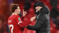Jurgen Klopp (kanan) memberi selamat kepada Curtis Jones setelah meraih kemenangan di akhir pertandingan sepak bola perempat final Piala Liga Inggris antara Liverpool melawan West Ham United di Anfield, Liverpool, barat laut Inggris, pada 20 Desember 2023. Liverpool menang 5-1 atas West Ham United. (Oli SCARFF/AFP)