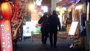 Warga berjalan di antara bar dan restoran, Tokyo, Jepang, 21 Januari 2022. Tokyo dan selusin area lain di Jepang akan menutup restoran dan bar lebih awal karena lonjakan kasus COVID-19 akibat varian Omicron. (AP Photo/Koji Sasahara)