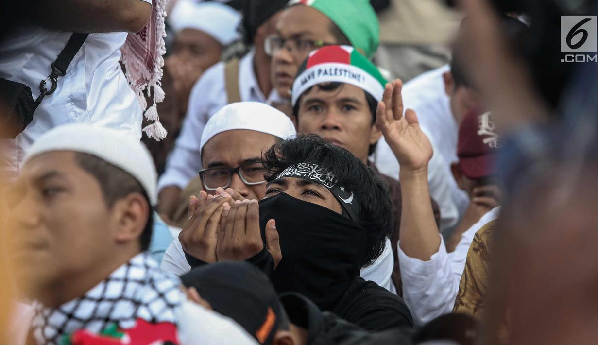 Peserta Aksi Bela Palestina berdoa saat unjuk rasa di kawasan silang Monas, Jakarta, Minggu (17/12). Aksi ini dilakukan untuk menentang keras pengakuan sepihak Presiden AS Donald Trump atas Yerusalem sebagai ibu kota Israel. (Liputan6.com/Faizal Fanani)