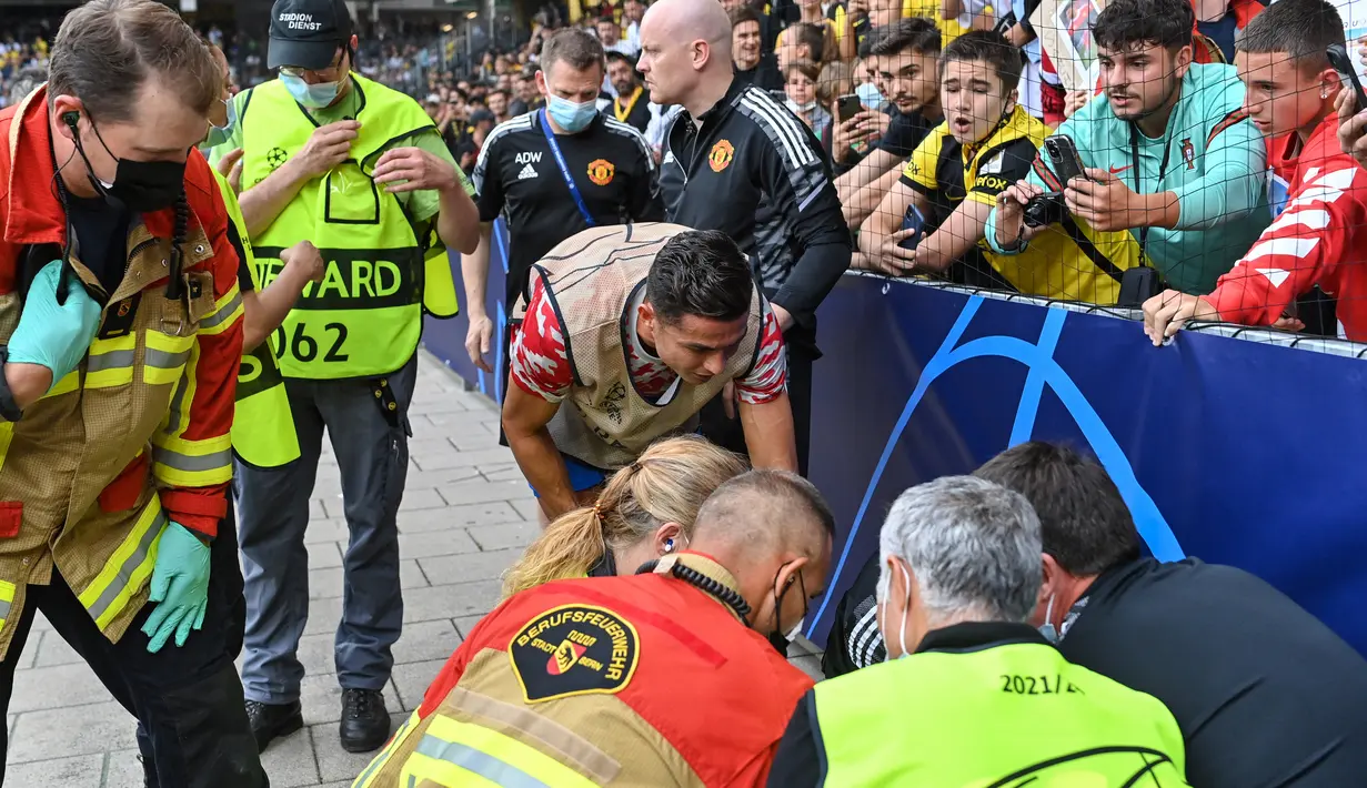 Cristiano Ronaldo meminta maaf kepada petugas lapangan yang terkena tendangan kerasnya saat sesi pemanasan jelang laga Liga Champions antara Young Boys vs Manchester United di Stadion Wankdorf, Rabu (14/9/2021). Bola sepakan Ronaldo mengenai petugas itu hingga terkapar. (Fabrice COFFRINI/AFP)