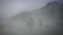 Orang-orang menikmati air panas di mata air mineral alami pada hari musim dingin di dekat desa Rupite, Bulgaria (2/2/2022). Penduduk setempat percaya bahwa air mineral menyembuhkan banyak penyakit dan gangguan. (AFP/Nikolay Doychinov)