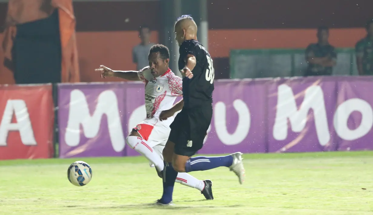 Pemain Persipura Jayapura, Ferinando Pahabol (kiri) berebut bola dengan pemain Arema Cronus Kiko pada laga grup E Piala Jenderal Sudirman di Stadion Maguwoharjo, Sleman, Minggu (13/12/2015) (Bola.com/Nicklas Hanoatubun) 