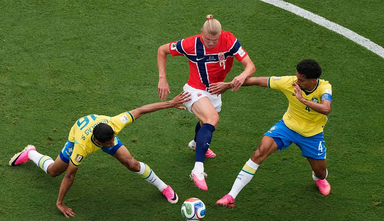 Pemain Norwegia Erling Haaland berebut bola dengan pemain Brasil Douglas Santos dan Marquinhos selama pertandingan sepak bola babak 16 besar Piala Dunia antara Brasil dan Norwegia di East Rutherford, N.J., dekat New York, Minggu, 5 Juli 2026. (AP Photo/Matt Slocum)