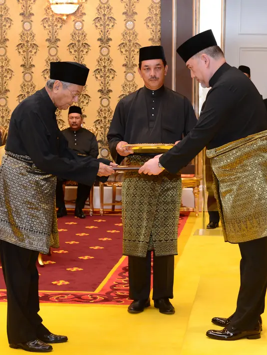 Perdana Menteri Malaysia baru, Mahathir Mohamad (kiri) saat melakukan sumpah jabatan di Istana Nasional di Kuala Lumpur (10/5). Mahathir pertama kali menjadi perdana menteri pada 16 Juli 1981. (AFP Photo/ Istana Nasional Malaysia)