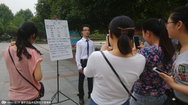 Pemuda ini sedang mengiklankan diri untuk dapatkan kekasih di depan kampus di Wuhan, China | Photo: Copyright shanghaiist.com