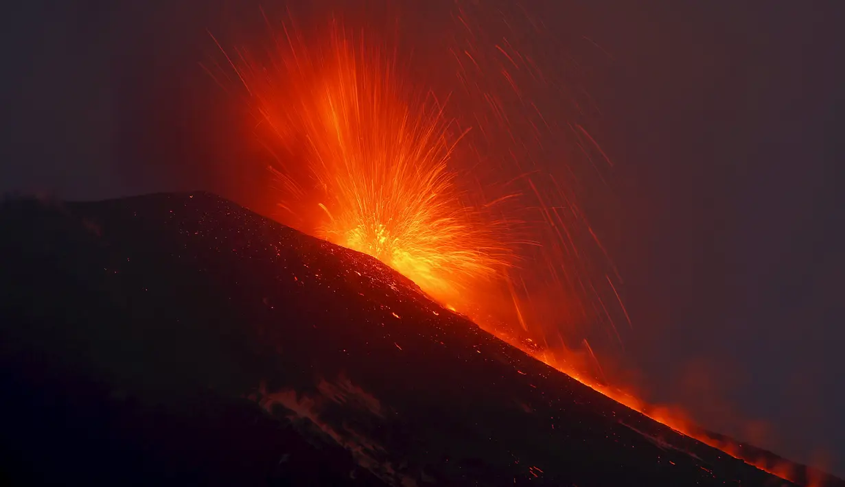 Gunung Etna mengeluarkan lava panas saat meletus di pulau selatan Sisilia, Italia, Senin (7/12). Gunung berapi tertinggi di Eropa tersebut kembali memuntahkan abu vulkanik setelah dua tahun tidak ada aktivitas. (REUTERS/Antonio Parrinello)