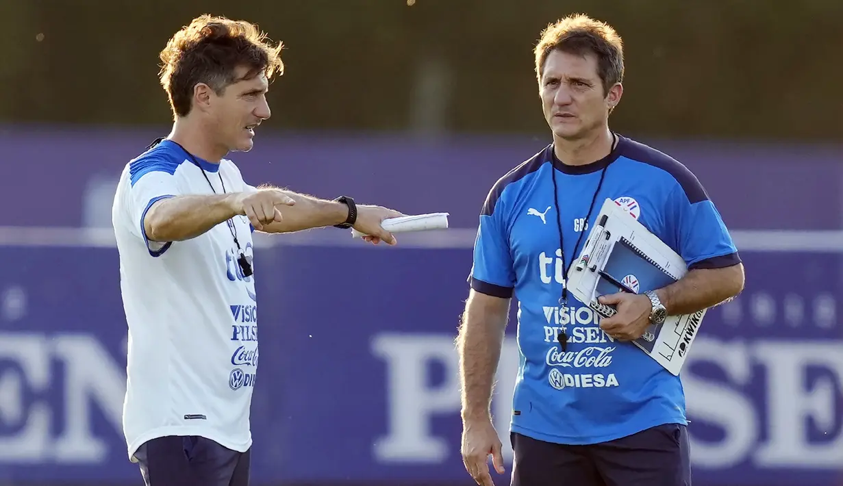 Pelatih Parguay Gustavo Barros Schelotto (kiri) dan saudaranya Guillermo berbicara selama sesi latihan di Ypane, Paraguay, Selasa (9/11/2021). Paraguay akan bertanding melawan Chile pada kualifikasi Piala Dunia di Estadio Defensores del Chaco. (AP Photo/Jorge Saenz)