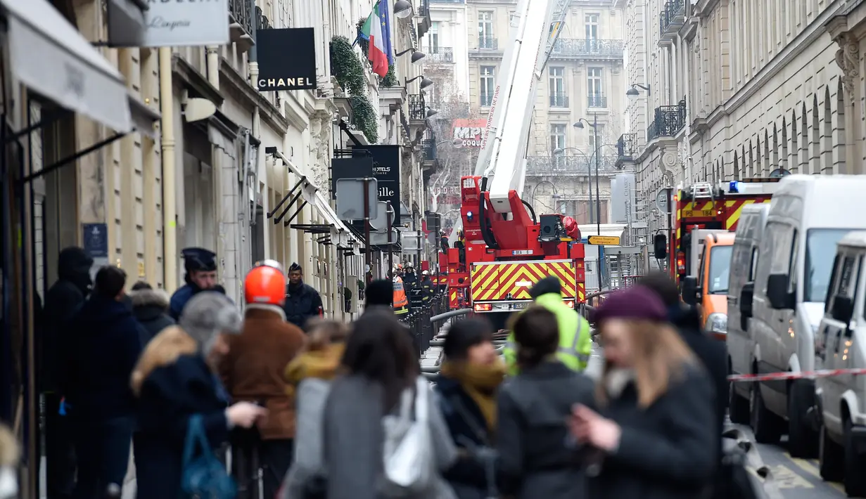 Petugas pemadam saat berusaha memadamkan api yang membakar lantai atas Hotel Ritz, Paris, Selasa (19/1). Enam puluh petugas pemadam kebakaran dan 15 mobil pemadam kebakaran dikerahkan untuk memadamkan api.  (AFP PHOTO/Lionel Bonaventure)