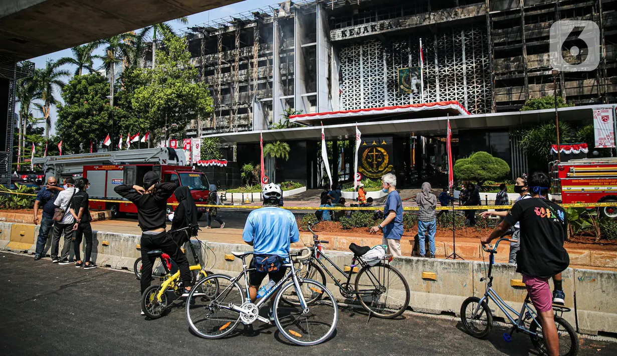 Warga melihat gedung utama Kejaksaan Agung RI yang terbakar di Jalan Sultan Hasanuddin, Jakarta Selatan, Minggu (23/8/2020).  Banyak warga yang memadati Jalan Hasanuddin untuk melihat langsung kondisi gedung Kejaksaan Agung yang hangus dilalap api. (Liputan6.com/Faizal Fanani)