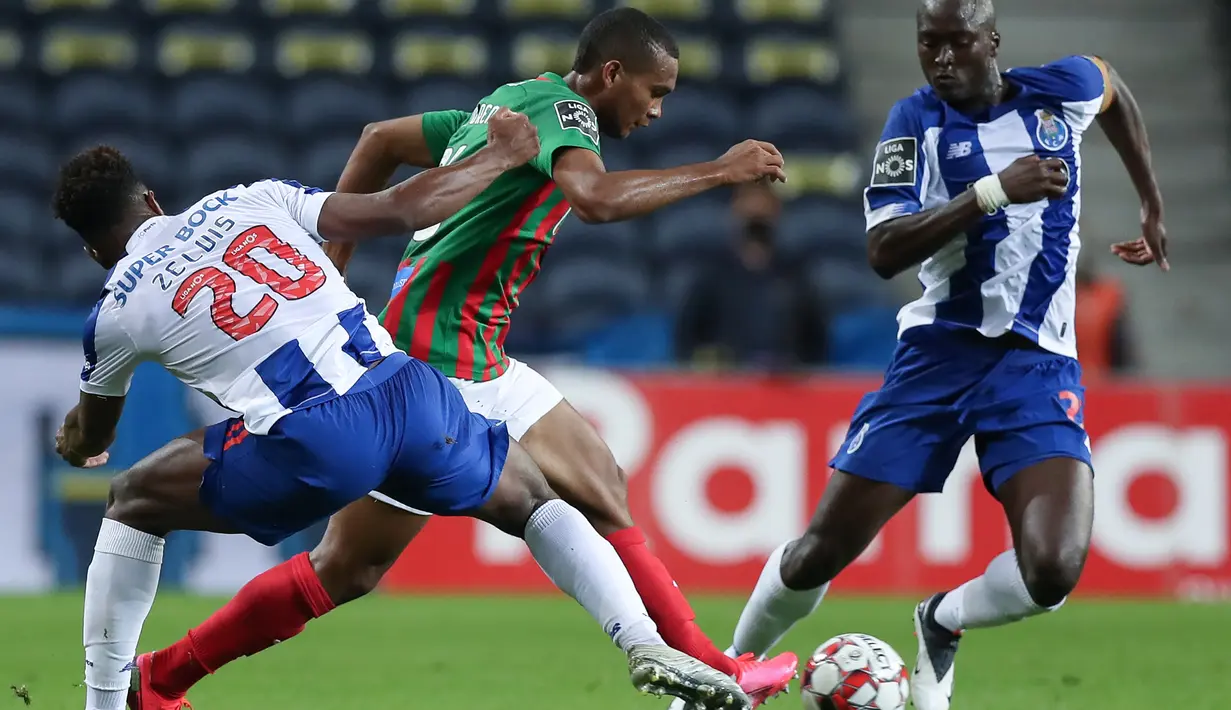 Striker FC Porto, Ze Luis, berebut bola dengan gelandang Maritimo, Diego Moreno, pada laga lanjutan Liga Portugal di Dragao Stadium, Porto, Kamis (10/6/2020) waktu setempat. Porto menang tipis 1-0 atas Maritimo. (AFP/Jose Coelho/Pool)