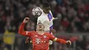 Penyerang Bayern Munchen, Thomas Mueller melompat berebut bola dengan pemain PSG, Nuno Mendes pada pertandingan leg 2 babak 16 besar Liga Champions di Allianz Arena di Munich, Jerman, Kamis (9/3/2023). Bayern menang atas PSG dengan 2-0. (AP Photo/Matthias Schrader)