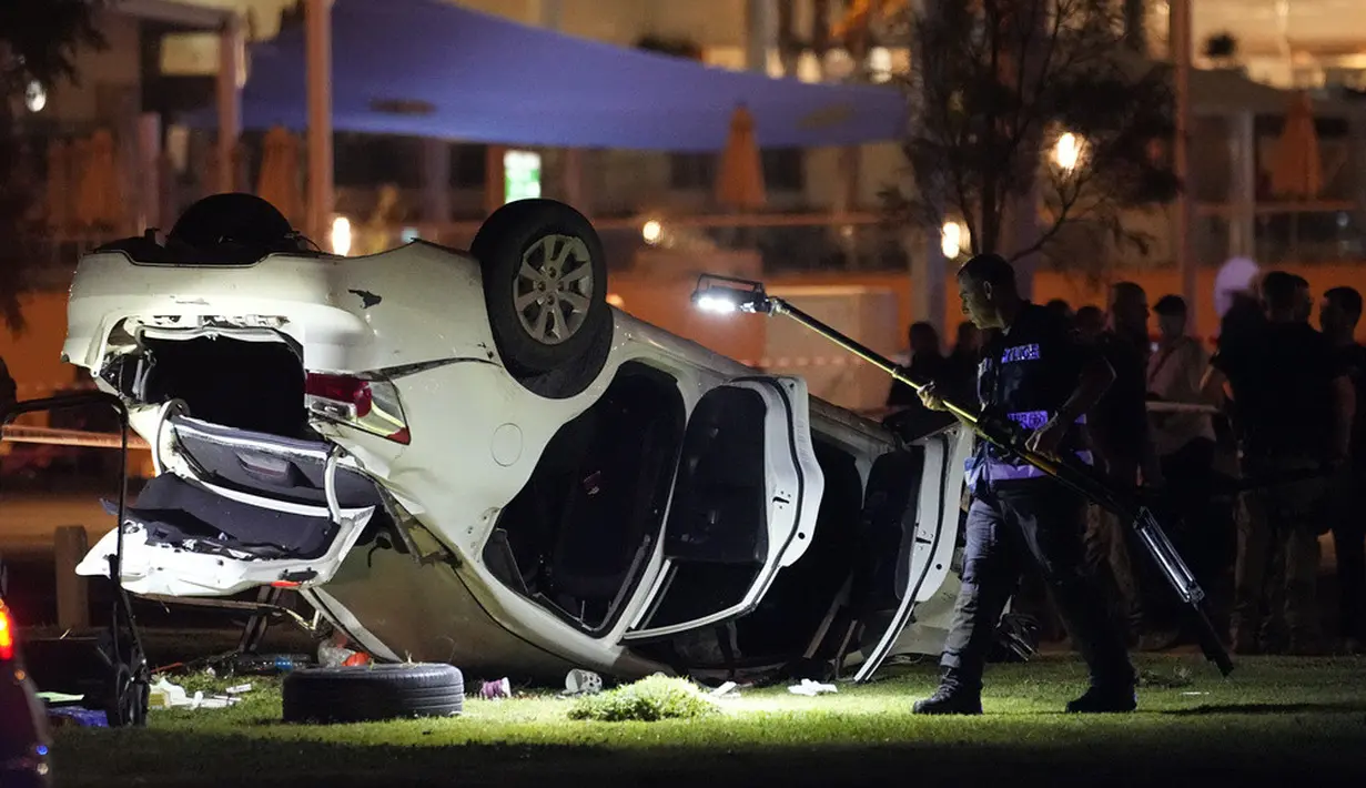 <p>Polisi dan layanan darurat bekerja di sekitar mobil yang terlibat dalam serangan di Tel Aviv, Israel, Jumat (7/4/2023). Polisi Israel mengatakan sebuah mobil menabrak sekelompok orang dekat taman pantai yang populer sebelum terbalik. (AP Photo/Ariel Schalit)</p>