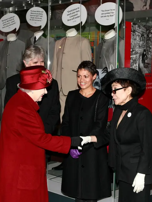 Ini adalah Yoko Ono di tahun 2011 saat ia bertemu dengan Ratu Elizabeth. Yoko Ono mengenakan setelan serba hitam dengan topi yang serasi, serta sarung tangan putih. Foto: Website.