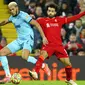 Pemain Newcastle United Joelinton (kiri) berduel memperebutkan bola dengan pemain Liverpool Mohamed Salah pada pertandingan sepak bola Liga Inggris di Stadion Anfield, Liverpool, Inggris, 16 Desember 2021. Liverpool menang 3-1. (AP Photo/Jon Super)