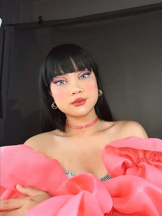 Tren foto Barbie, Hanum Mega menghadirkan makeup look bak Barbie hidup. Sempurna dengan area mata dan bibir yang benar-benar serupa Barbie, Hanum tak tanggung-tanggung tampil dengan wig hitam dan outfit dramatis bernuansa merah muda, dan kalung choker. Foto: Instagram.